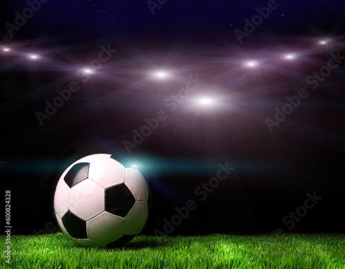 Soccer ball on grass against black background © Designpics