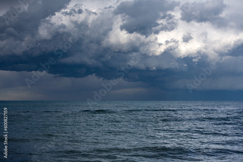 Landscape photo of dark grey thunderstorm clouds over the sea