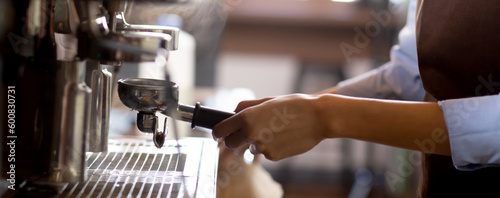 Foto Closeup hands of young asian woman holding coffee grinder powder while mashed for preparing making coffee in cafe, barista using coffeemaker for making black coffee, small business or SME