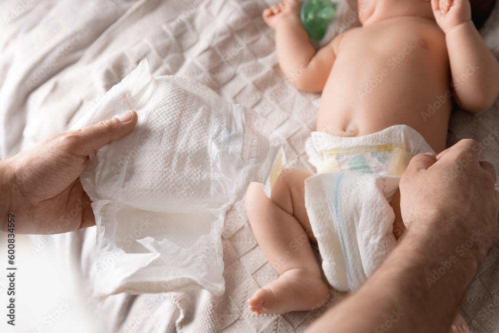 Father changes diapers with newborn baby, top view Father changes diapers with newborn baby, top view