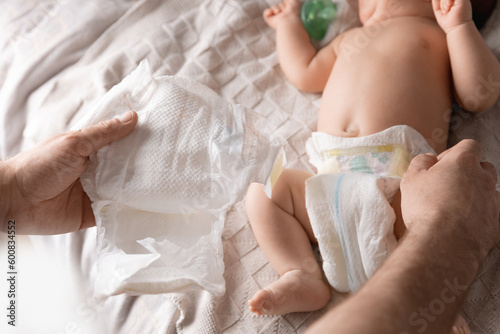 Fotografie Father changes diapers with newborn baby, top view