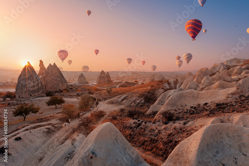 Landscape sunset in Cappadocia, travel tour excursion on horse with hot air balloons in Goreme Turkey