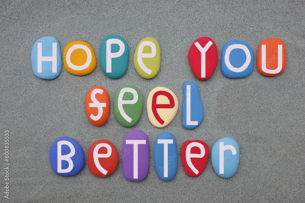 Hope you feel better, friendly message composed with multi colored stone letters over green sand Hope you feel better, friendly message composed with multi colored stone letters over green sand