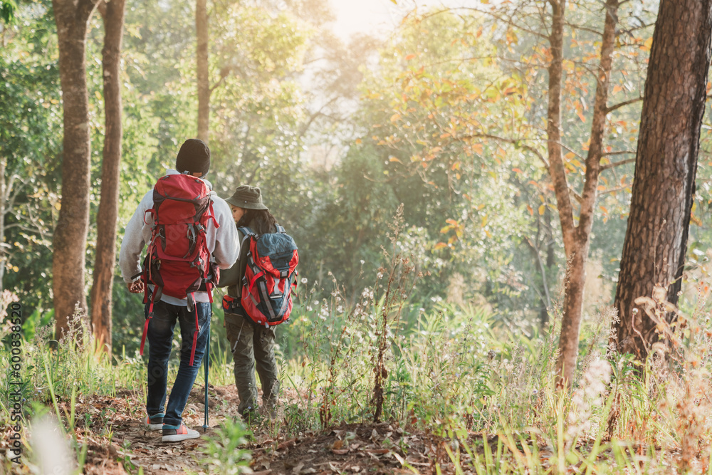 Travelers hiking with backpack traveling in forest wild and look around and explore while walking in nature wood. happy holiday vacation trip.