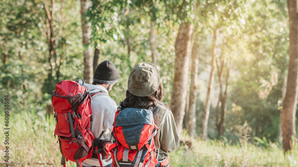 Travelers hiking with backpack traveling in forest wild and look around and explore while walking in nature wood. happy holiday vacation trip.
