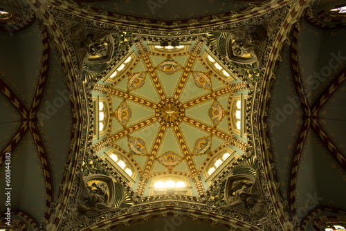 Toma en contrapicada de una bóveda con candelabros e iluminación dentro de una iglesia. photo