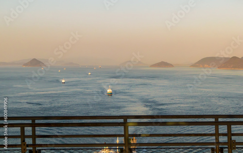 Scenic evening seascape with the islands and boats crossing the Seto Inland Sea viewed from Kita Bisanseto Bridge in Japan photo