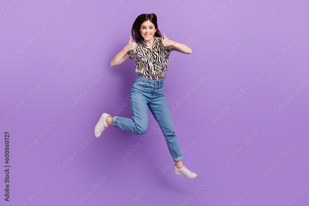 Full length portrait of energetic pretty person jumping demonstrate thumb up isolated on purple color background