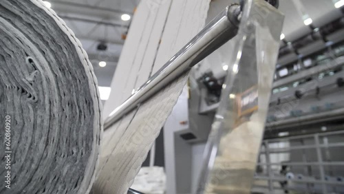 On modern machines manufactured upholstery fabric for furniture. On a large special equipment between the rollers lashed material for lining mattresses.