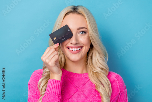 Photo of sweet cute woman dressed knitted pullover holding credit card cover eye isolated blue color background