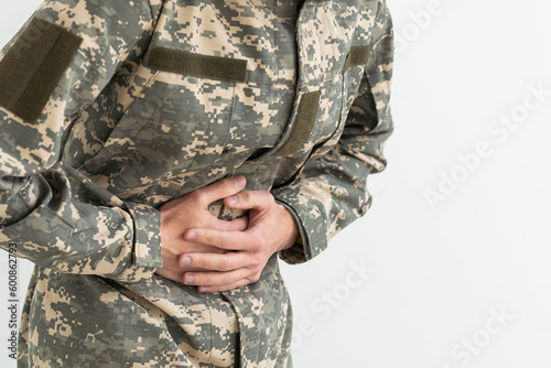 Young hispanic man wearing camouflage army uniform with hand on stomach because nausea, painful disease feeling unwell. ache concept