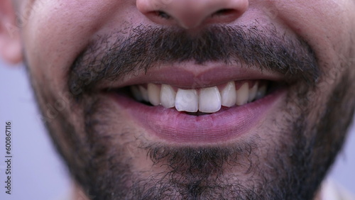 One happy MIddle Eastern man closeup mouth smile in macro. Bearded male person smiling at camera close up detail of teeth