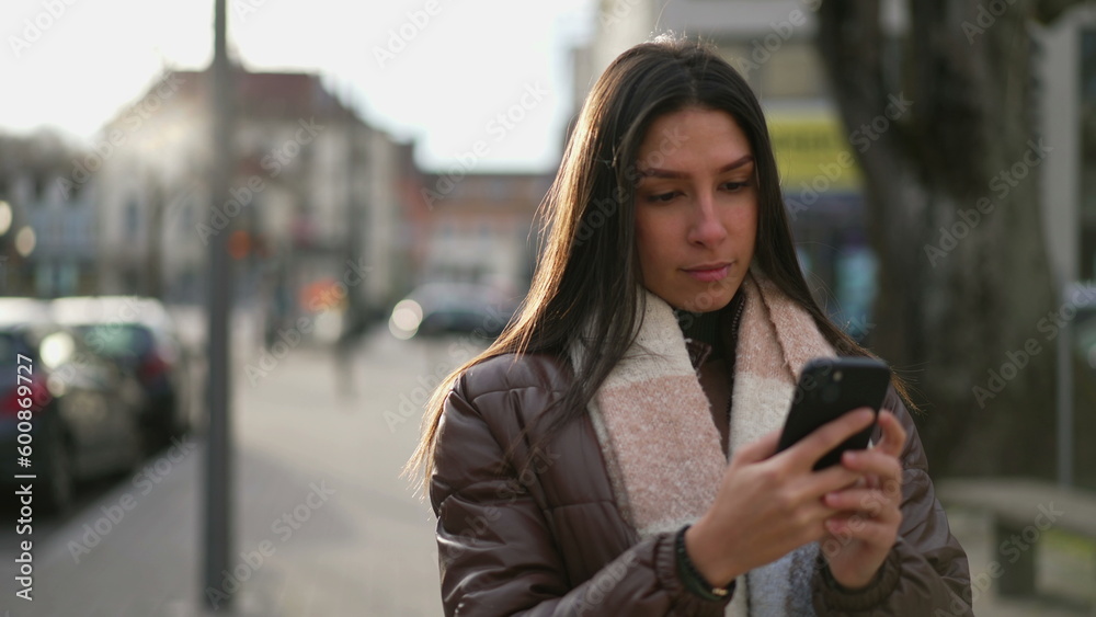 One beautiful young woman checking cellphone in urban environment One beautiful young woman checking cellphone in urban environment