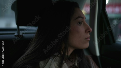 One Arab MIddle Eastern woman looking out car window sitting inside car backseat © Marco
