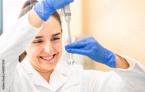 Scientist with dropper dripping liquid into a test tube in scientific laboratory  concept of pharmaceutical environment