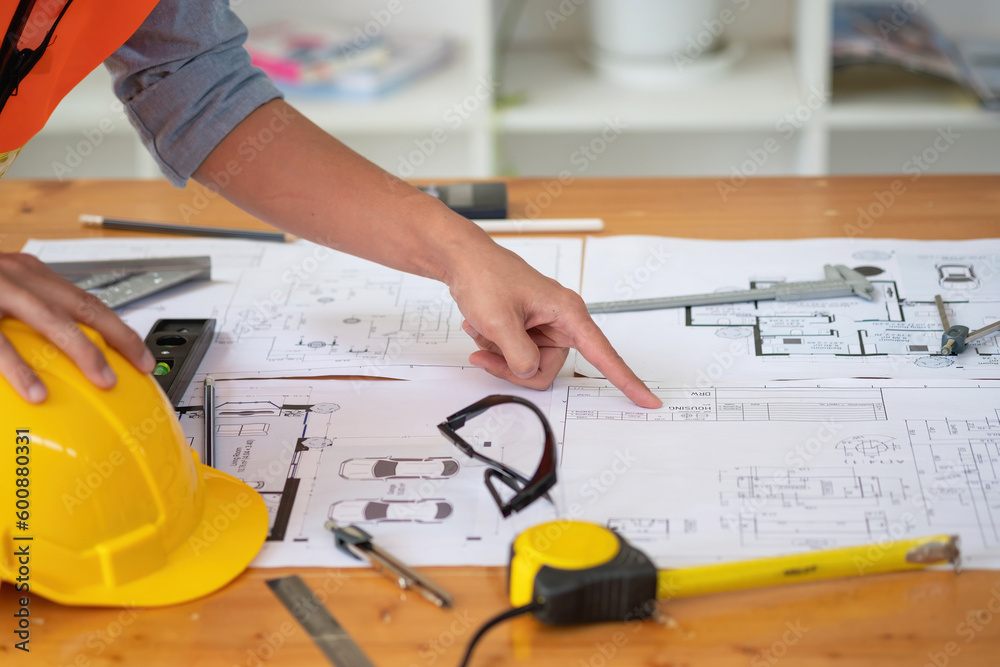 Asian engineers brainstorm and measure to document cost estimates and