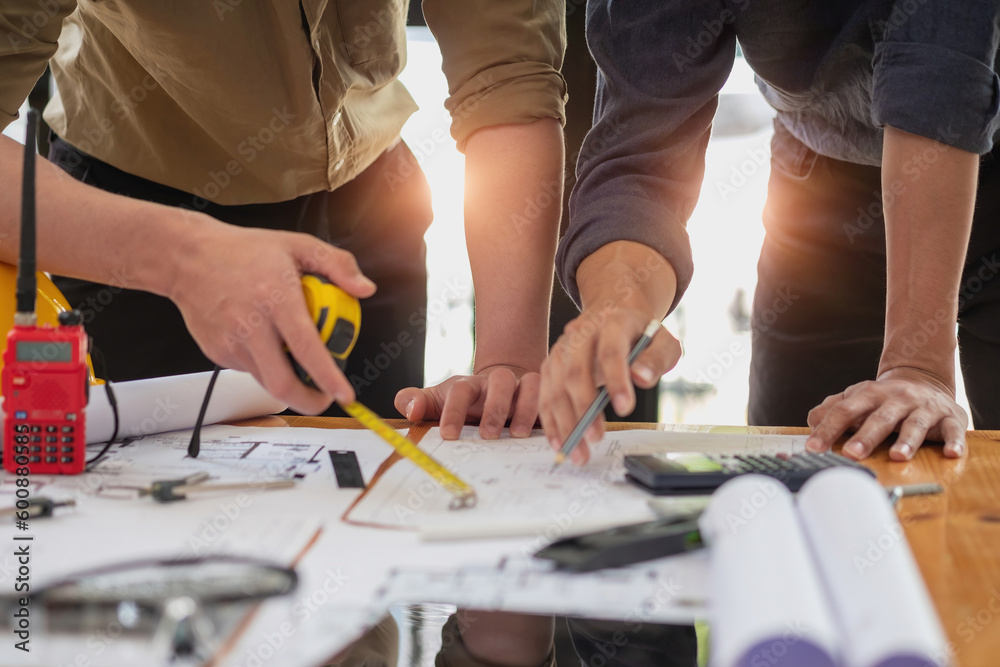 Asian engineers brainstorm and measure to document cost estimates and write floor plans for architectural and engineering designs for houses and buildings. Asian engineers brainstorm and measure to document cost estimates and write floor plans for architectural and engineering designs for houses and buildings.