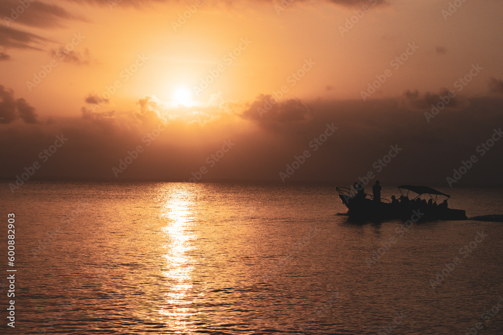 orange sunset in the sea with a tourism boat