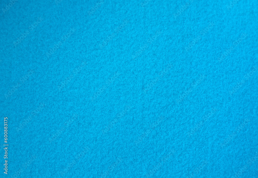 Photo of a soft blue background made of felt fabric. Pure sea-green background for text.