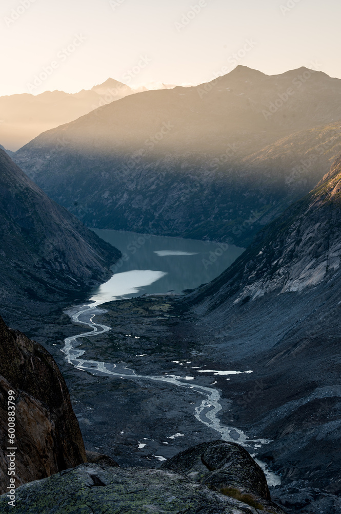 meandering creek after Unteraargletscher with Grimselsee on a sunny summer day