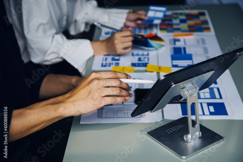 Close up ux developer and ui designer brainstorming about mobile app interface wireframe design on table with customer breif and color code at modern office.Creative digital development agency © ARMMY PICCA