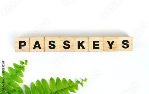 Wood block with text passkeys on white background. The new security system, in addition to being convenient and quick to log in, is also safer than entering a traditional password.   photo