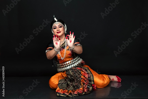 Woman performing Odissi dance in colorful costume. Indian classical dance forms.