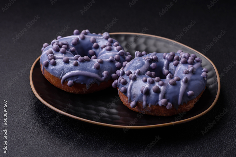 Delicious sweet donut of purple color in glaze and with lilac balls Delicious sweet donut of purple color in glaze and with lilac balls