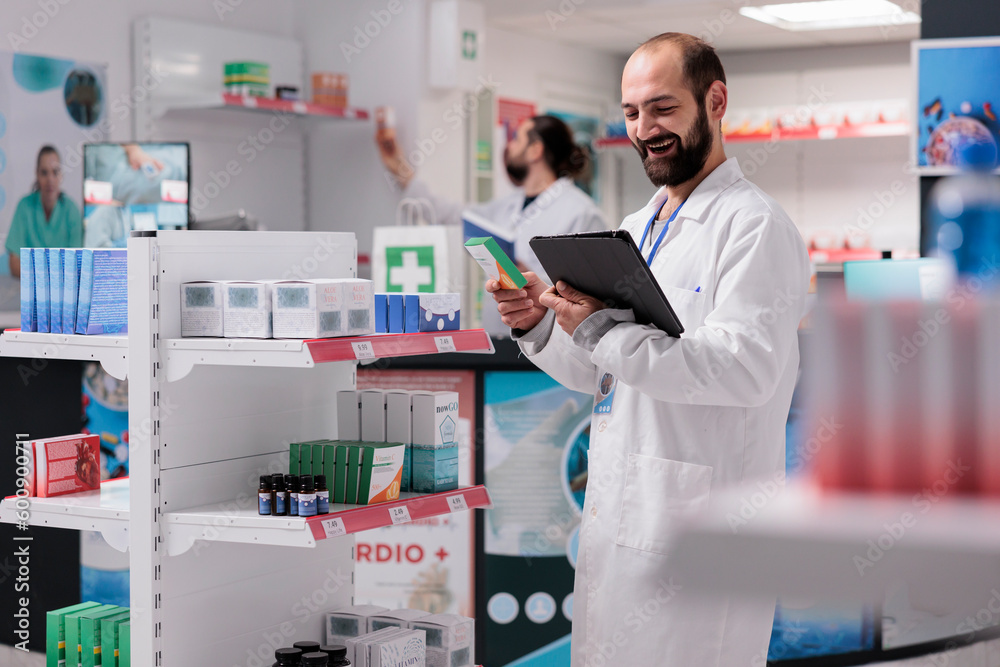 Pharmacist looking at vitamins packages being responsible for accurately filling and labeling medication prescriptions on tablet computer in pharmacy. Medicine support service and concept