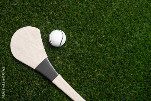 Hurling bat and sloitar on green grass. Horizontal sport theme poster, greeting cards, headers, website and app photo