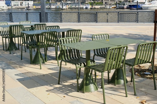 Modern metal tables and chairs are khaki color. Empty outdoor cafe. Urban street furniture © Matrix Reloaded