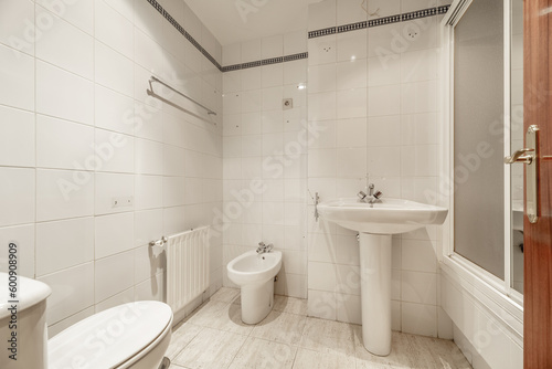 A full bathroom with showers with screens, white porcelain toilets