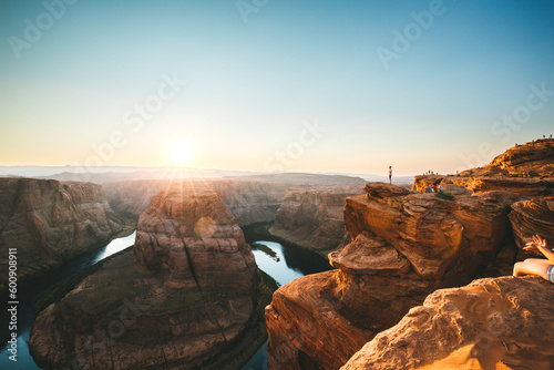 Man standing on the cliff of Horseshoe band and enjoing the sunset with the view of Colorado river in Arizona photo