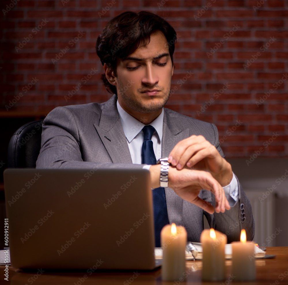 Businessman working late in office with candle light Businessman working late in office with candle light