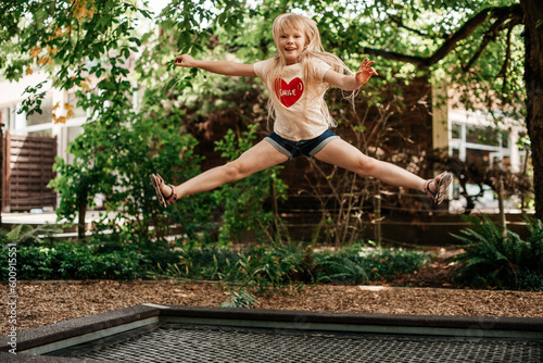Girl enjoy bouncing on a trampoline outdoors