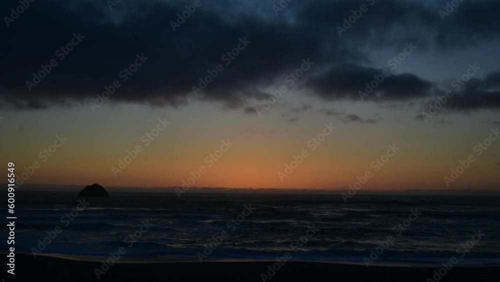 Stunning orange colourful sunset over the Pacific Ocean from California in time lapse video with clouds moving across the sun and light dying down. Stunning orange colourful sunset over the Pacific Ocean from California in time lapse video with clouds moving across the sun and light dying down.