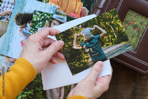Woman looks at printed photos for family photo album. photo