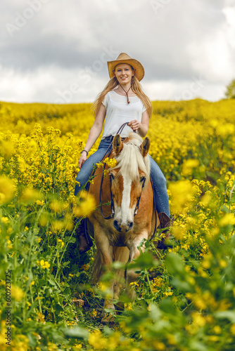 A young woman enjoying time with her haflinger horse in spring outdoors. Female equestrian friendship scene with her horse