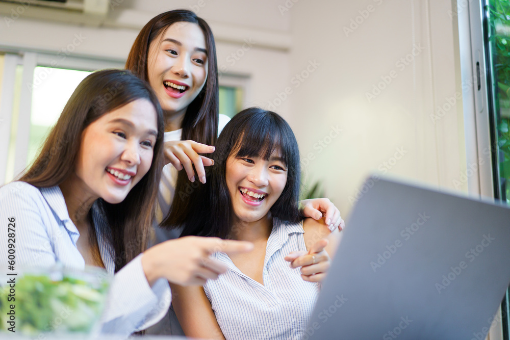 Group of Asian young women working and talking together on laptop or notebook computer in the dining room. Group of Asian young women working and talking together on laptop or notebook computer in the dining room.