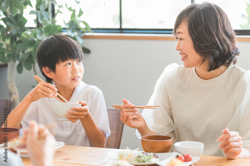 家の食卓で家族と朝食・ご飯を食べる成長期の子供（親子・ママと男の子）
