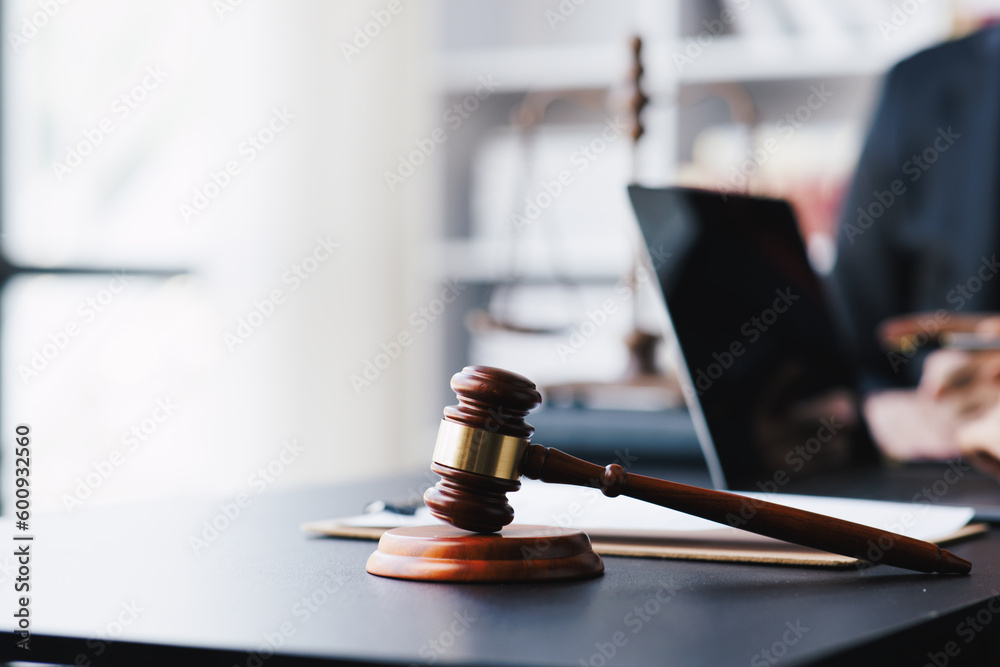 Lawyer working with client discussing contract papers with brass scale about legal legislation. Lawyer working with client discussing contract papers with brass scale about legal legislation.