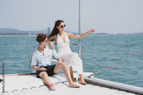 Caucasian couple who man and woman relax fun with luxury party drinking champagne by talking together while catamaran yacht boat sailing. Happy and enjoy outdoor lifestyle on summer vacation travel © chokniti