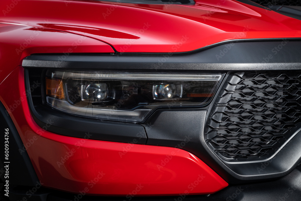 Red car headlights. Exterior detail. Close up detail on one of the LED headlights modern car..