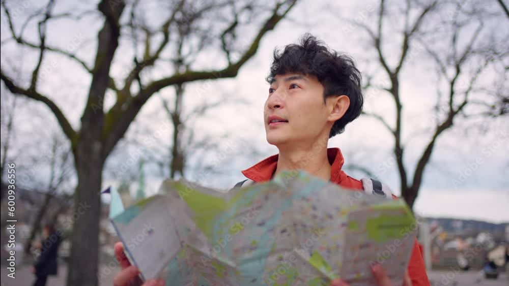 Asian young man backpacker traveler looking at map to find destination. Asian young man backpacker traveler looking at map to find destination.