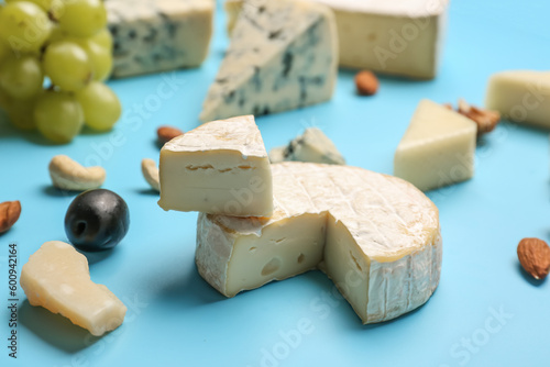 Pieces of tasty cheese on blue background