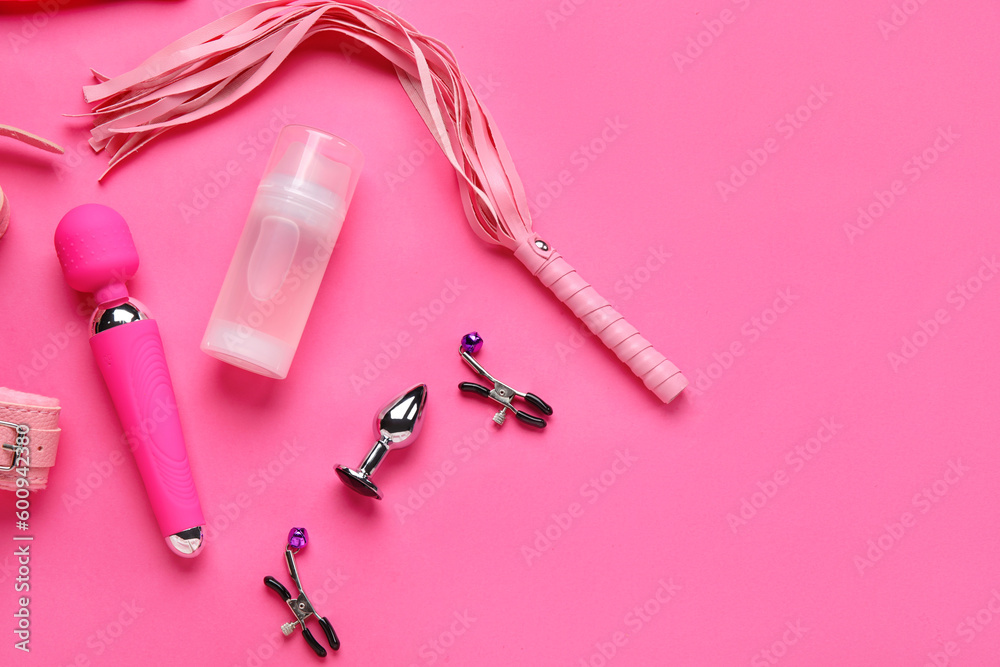 Bottle of lubricant and sex toys on pink background Bottle of lubricant and sex toys on pink background
