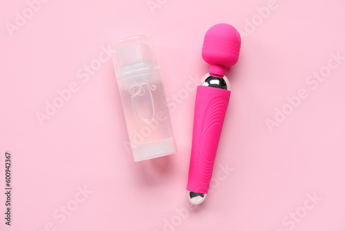 Vibrator and bottle of lubricant on pink background