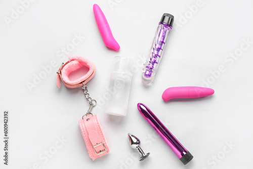 Bottle of lubricant and sex toys on grey background