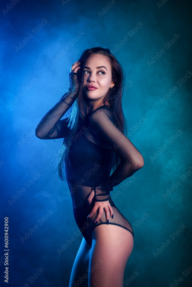 Beautiful woman in black lingerie posing against a blue and pink smoke on a black isolated background Beautiful woman in black lingerie posing against a blue and pink smoke on a black isolated background