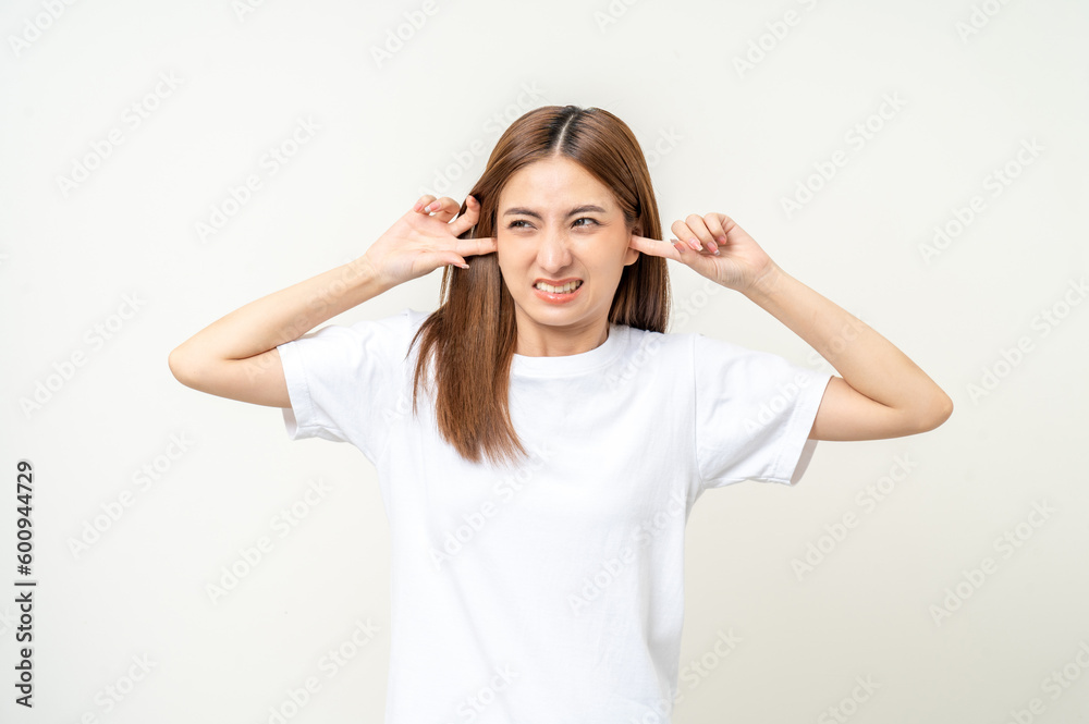 Woman stressed and frustrated covering her ears with her hands due to loud noise. Annoyed noise sound pollution. Asian Woman blocking ears Woman stressed and frustrated covering her ears with her hands due to loud noise. Annoyed noise sound pollution. Asian Woman blocking ears
